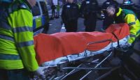 [The Doctor's body is taken away.]
